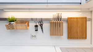 kitchenware hanging on the rail in the white glossy kitchen